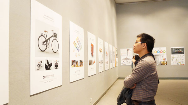 参会者在饶有兴趣地欣赏全国高校工业设计教学成果展